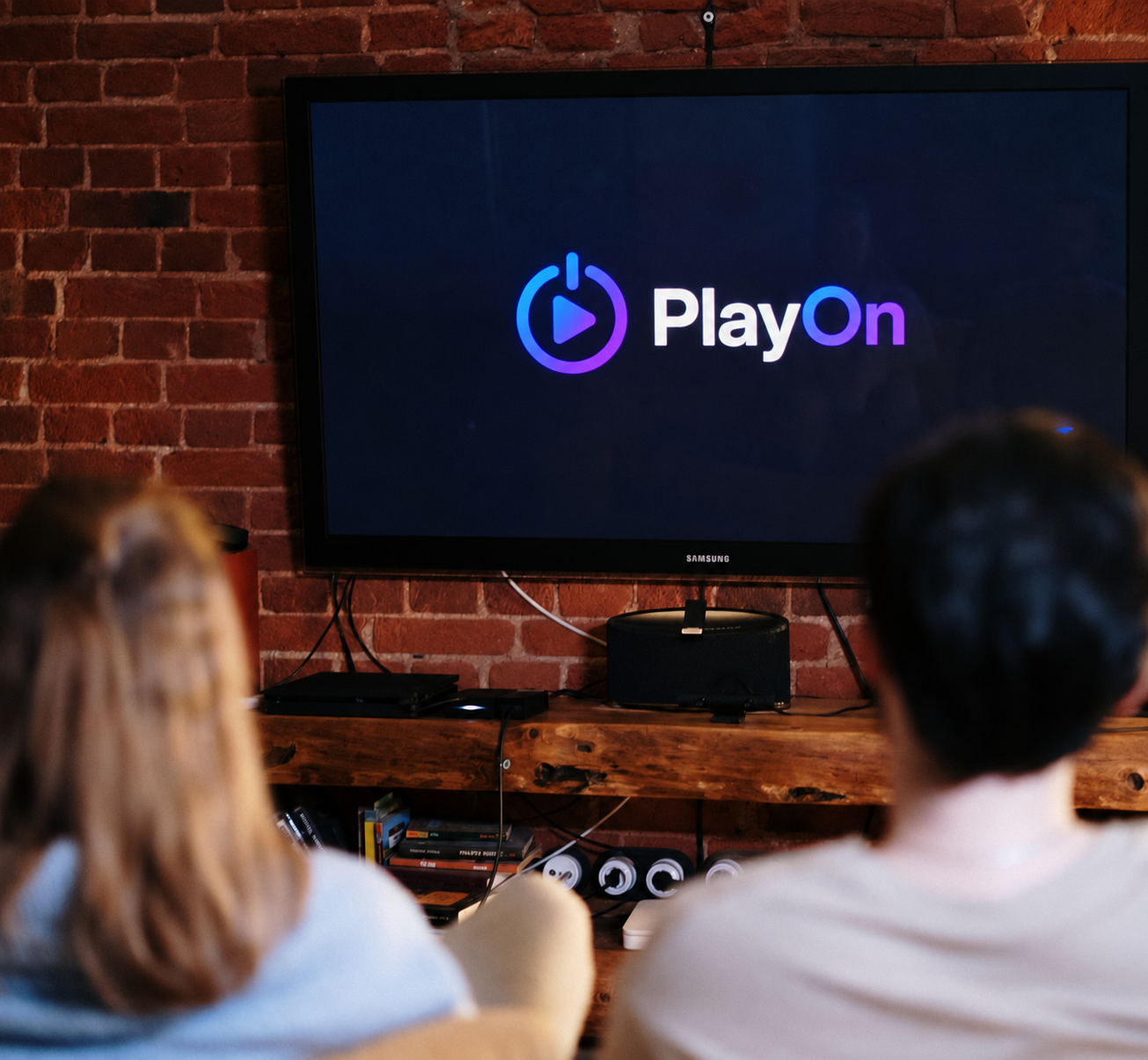 Casal assistindo à PlayOn em uma televisão
